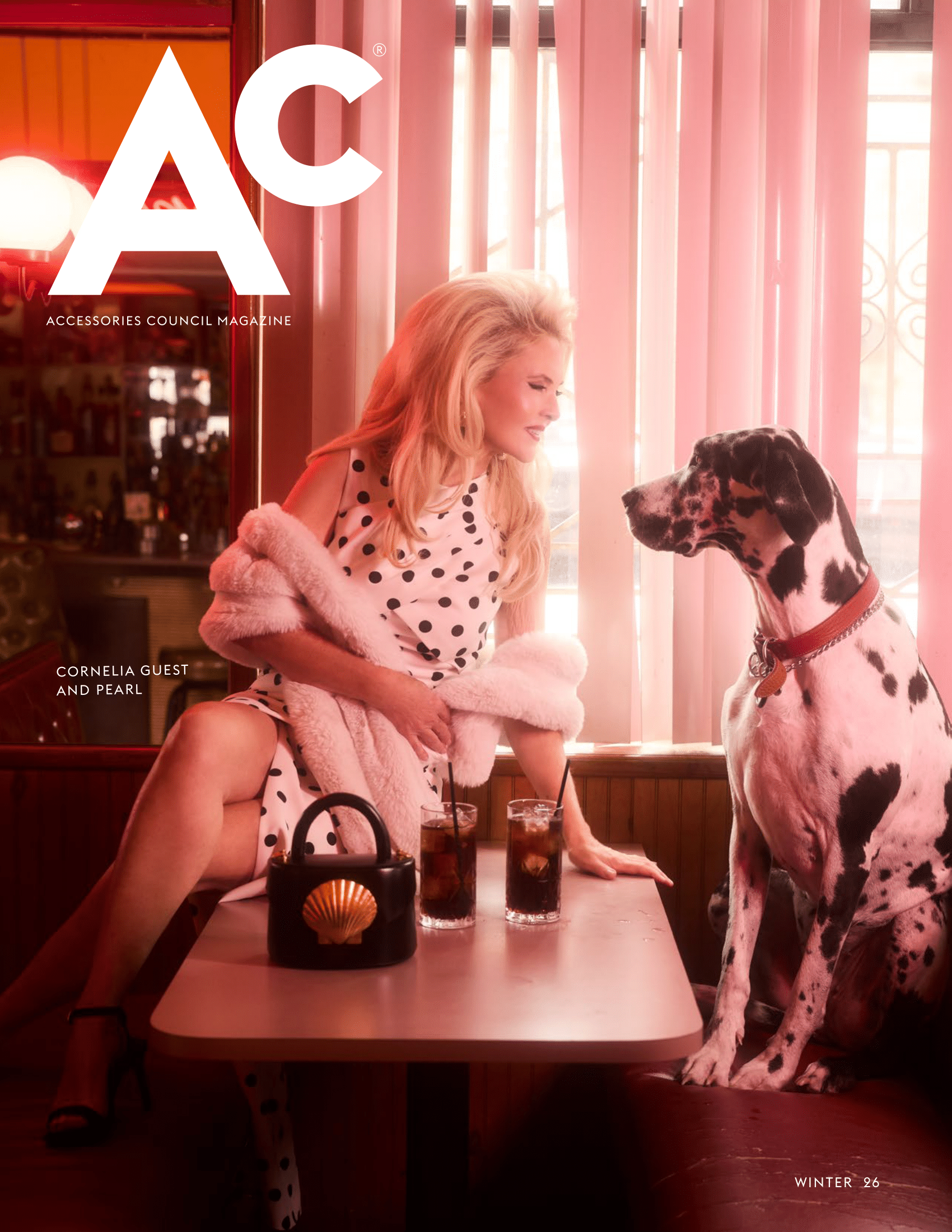 Ac Magazine Winter Issue 2026 Cover Featuring Cornelia Guest and her Dog Pearl. They are sitting in a retro-style diner dressed in black and white, featuring a handbag from the brand Flore K.