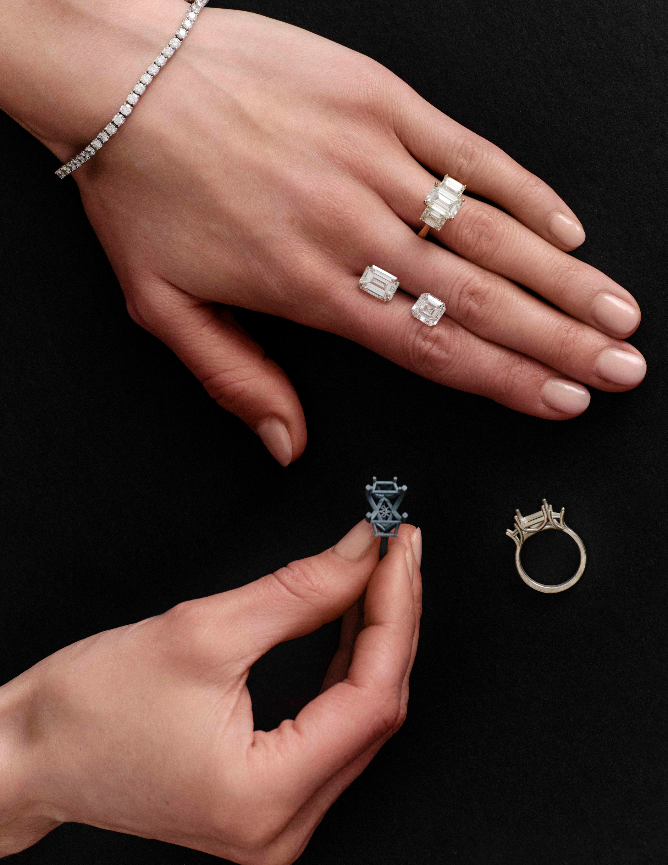 Close-up of hands showcasing Avermore diamond rings and a tennis bracelet, with additional ring settings displayed on a black background