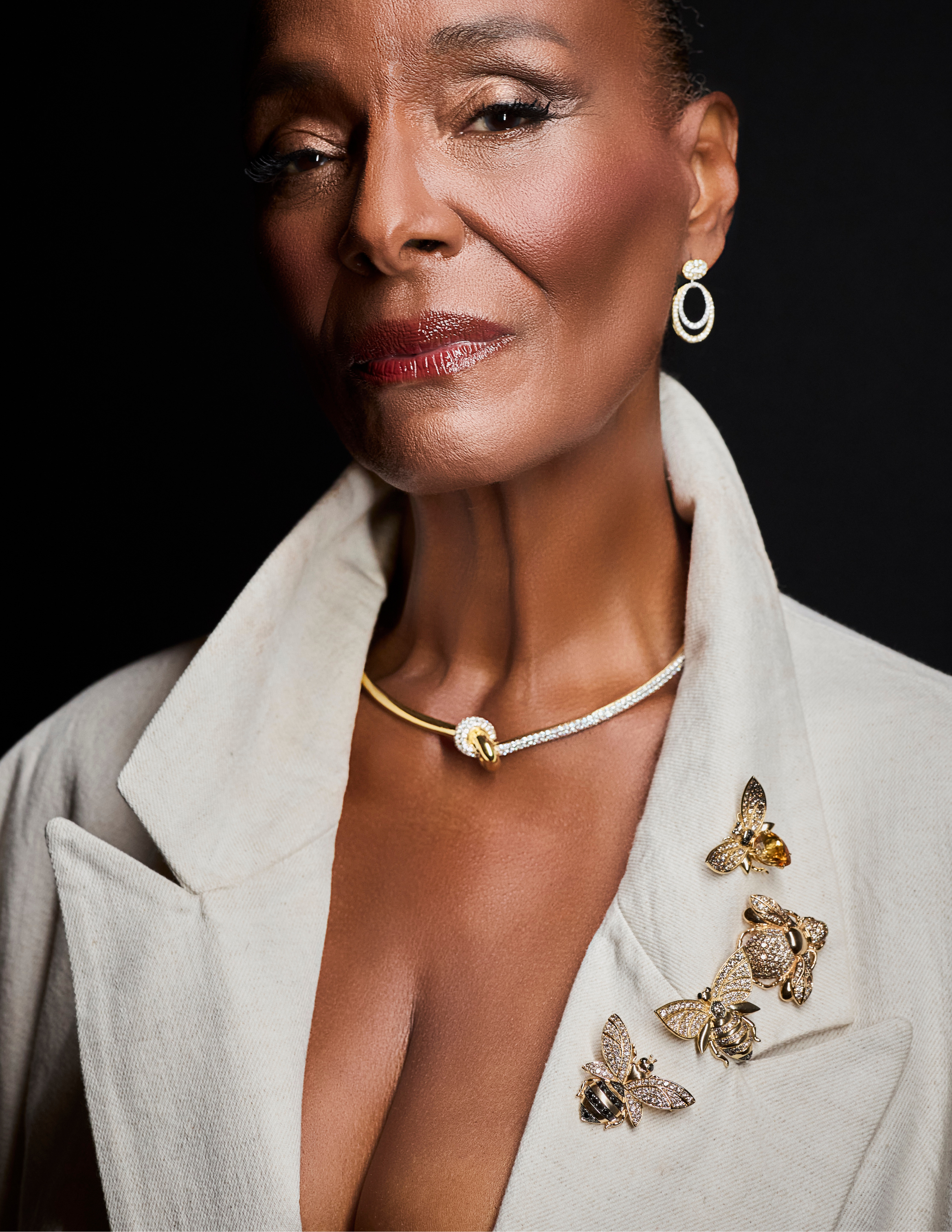 Anedra Shockley-Elsesser in a light colored blazer, wearing Simon G earrings and choker and LeVian pins.