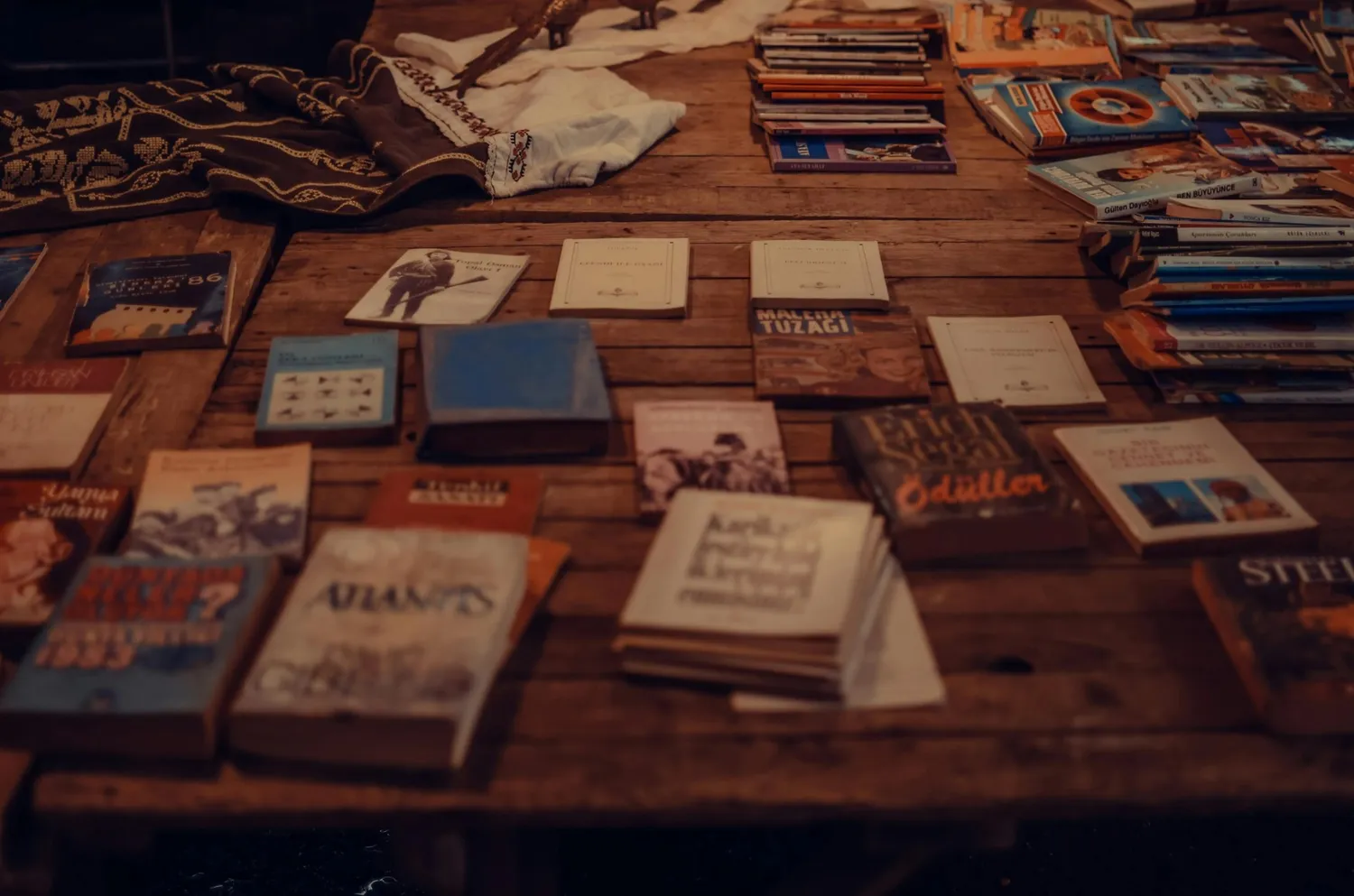 Table filled with various books and manuscripts, representing extensive research and support in dissertation editing and proofreading services.