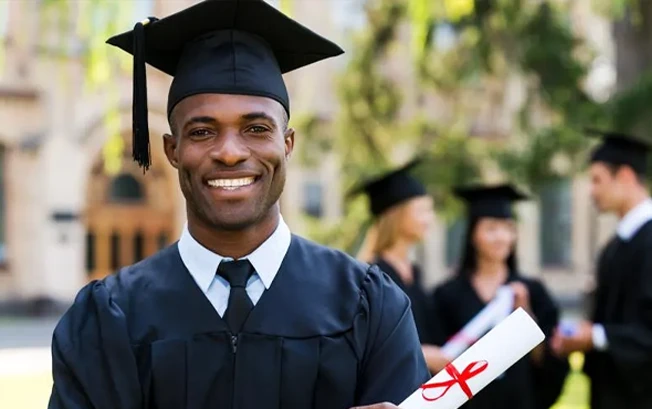 A college graduate posing with a diploma