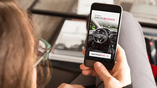 Woman booking a Nissan test drive online on a smartphone