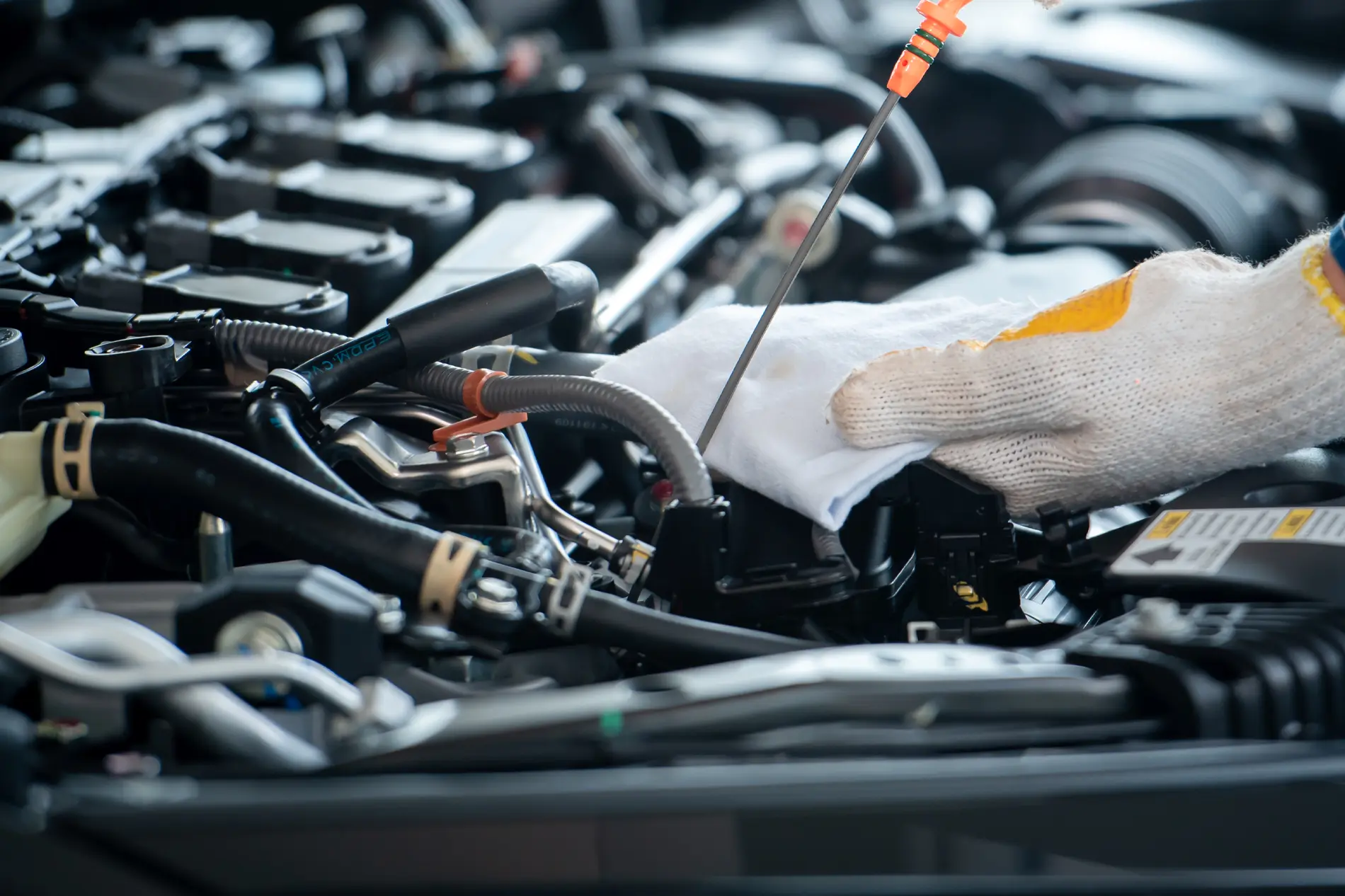A closeup of a technician checking the oil level in a vehicle