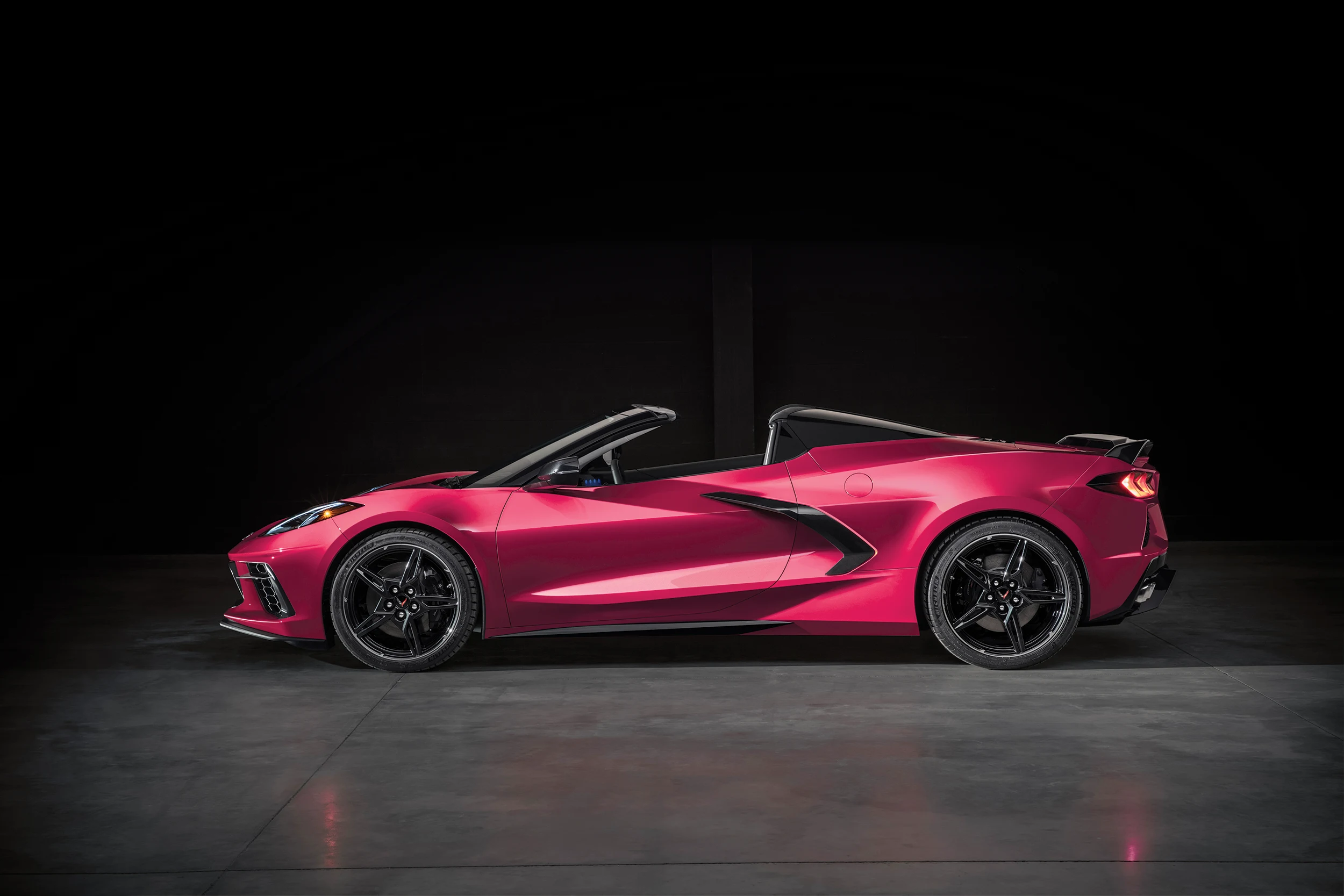 Driver side view of a pink Corvette