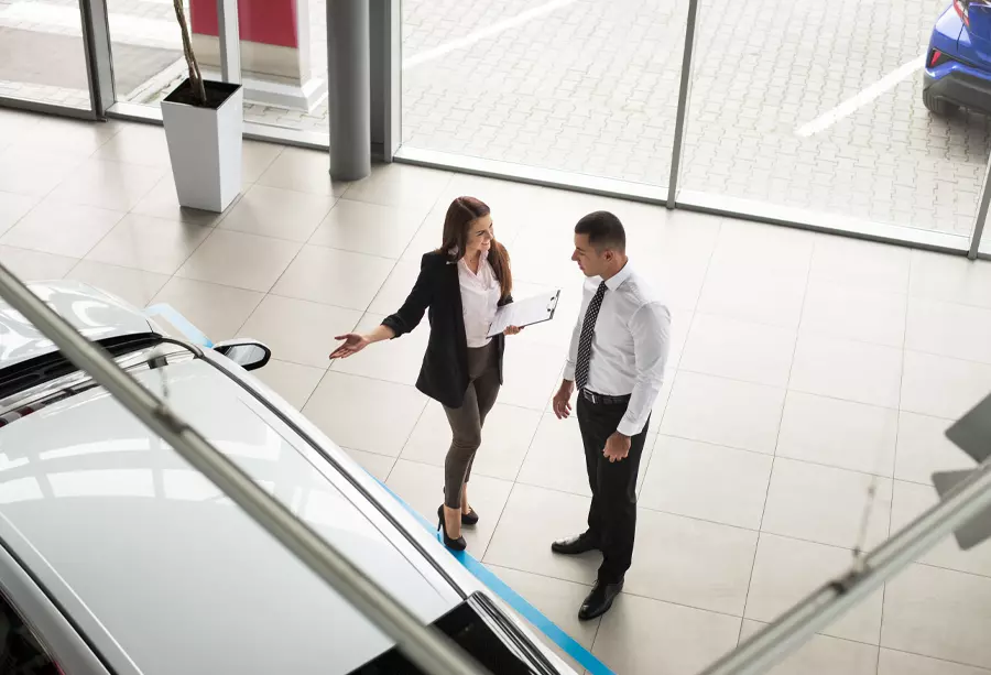 Overhead view of woman showing a man a vehicle
