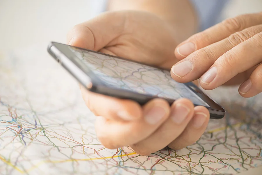 Closeup of a hand using a mobile phone taking a picture of a map