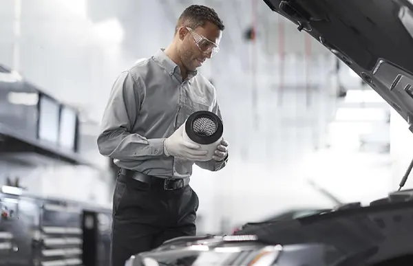 Audi Service Technician changing air filters on an Audi