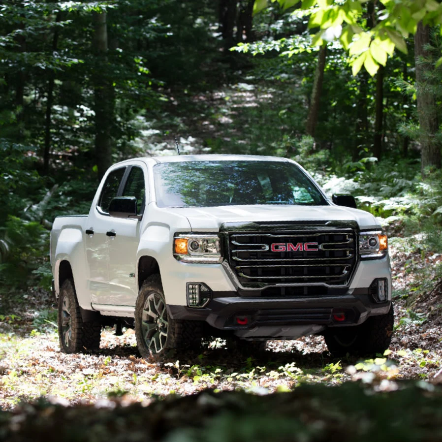 White 2022 GMC CANYON AT4 parked in the woods