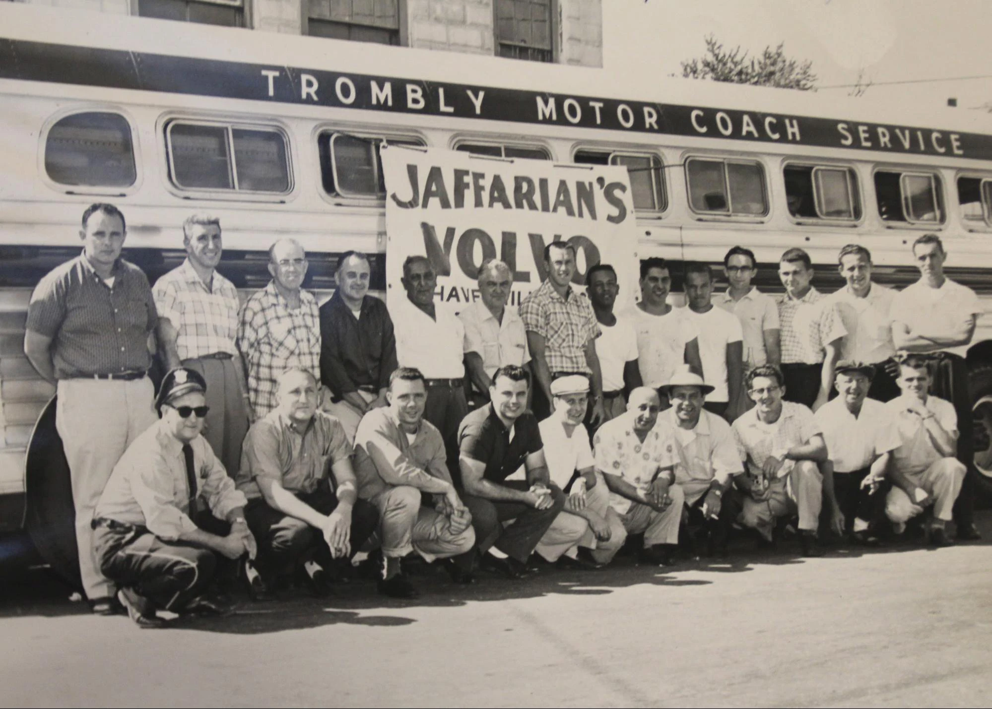 Jaffarian Volvo employees taking a group photo in front of an old bus