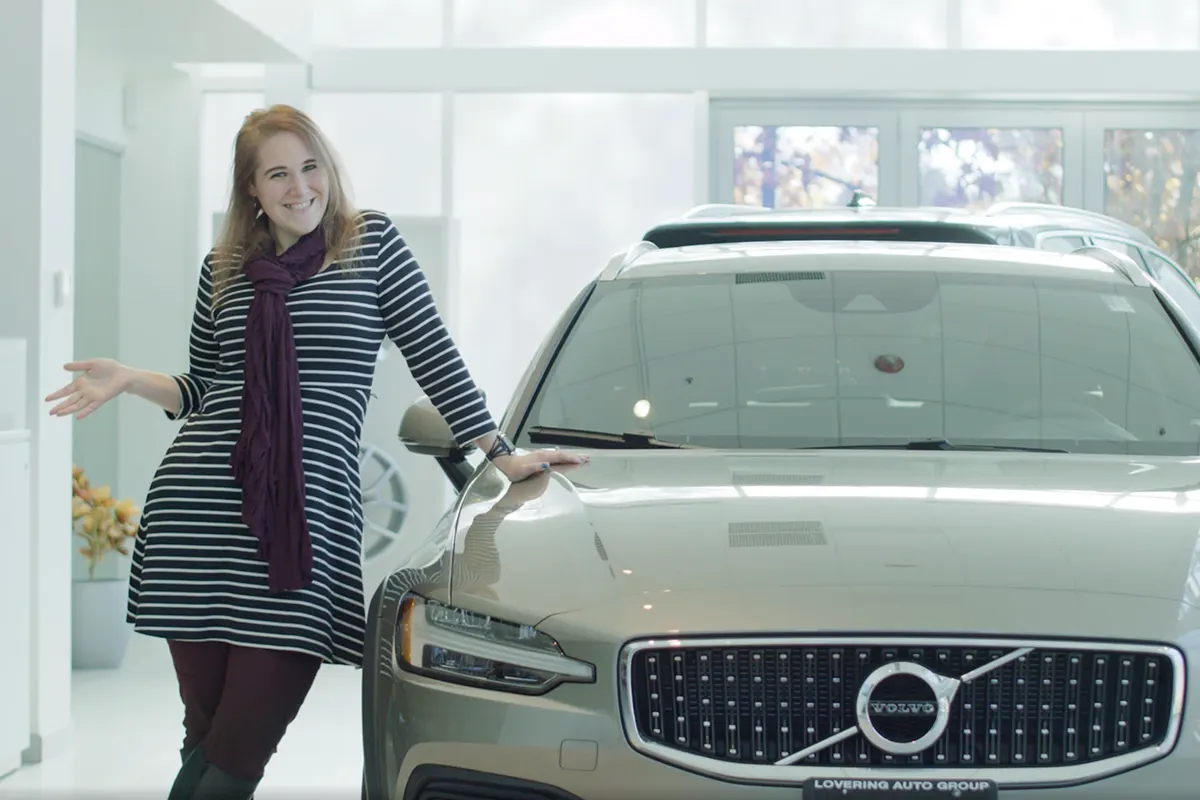 Woman standing next to Volvo