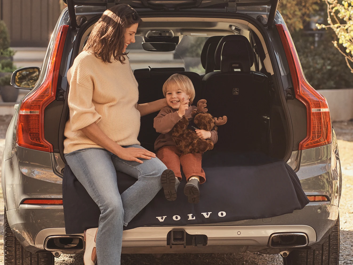 Mother and child sitting in back of Volvo