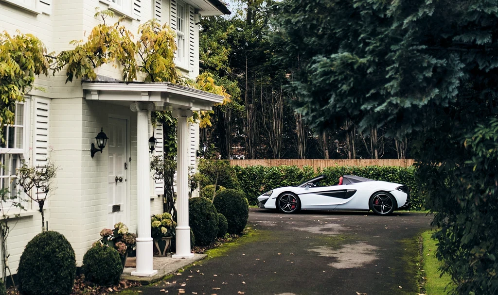 Photo of a McLaren by a home.