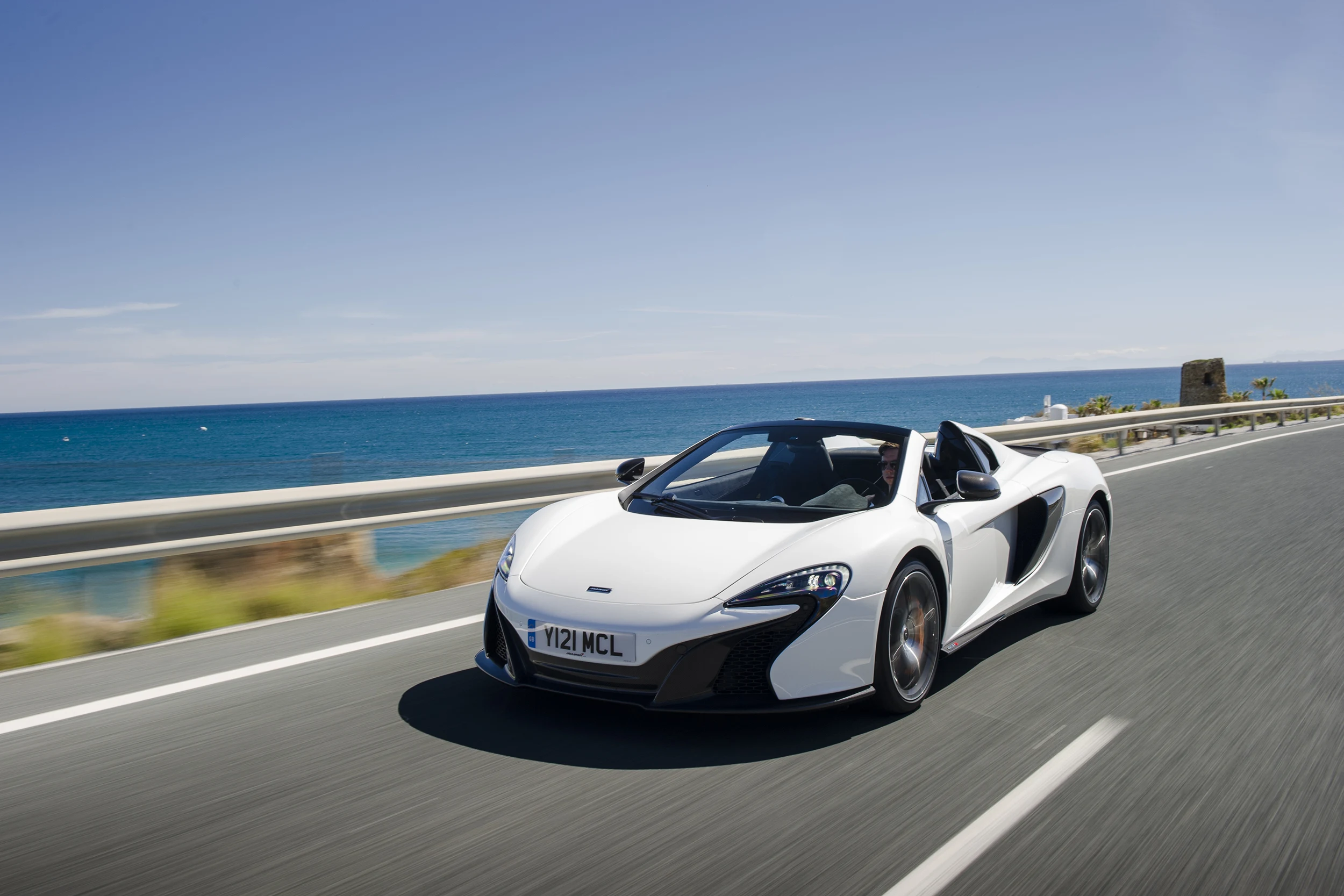 White 650S driving by the ocean