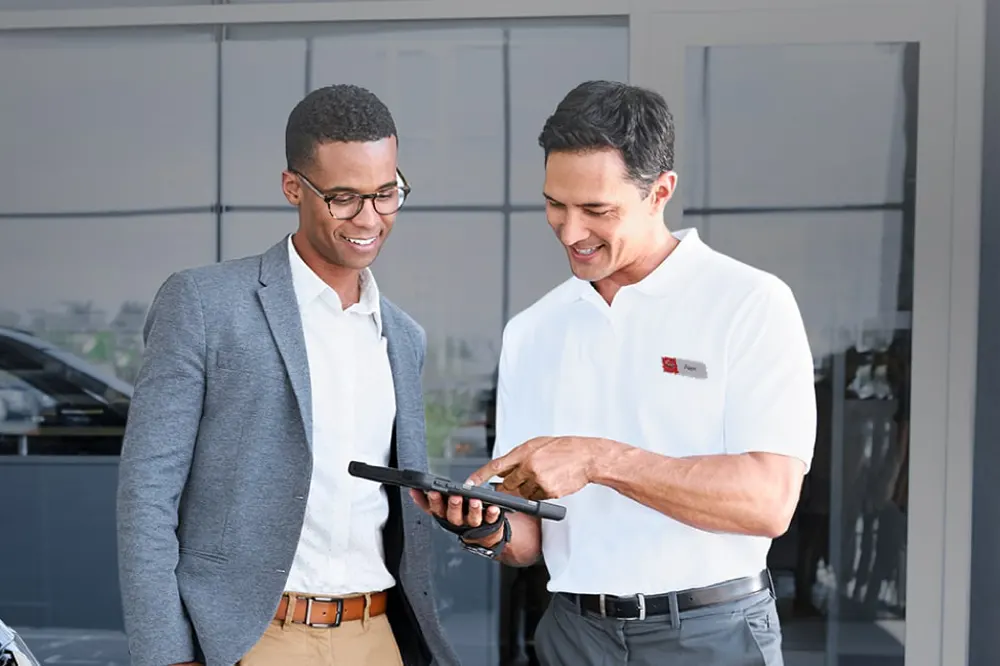 Nissan Salesman showing payment breakdown on a tablet to a potential buyer