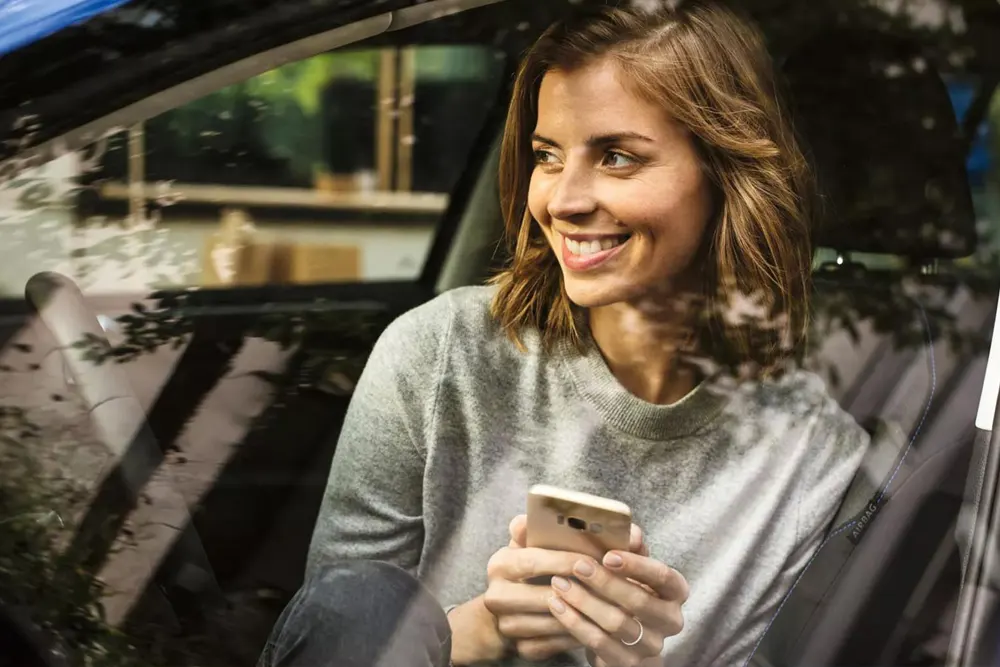 Woman smiling using her phone while personalizing her payment