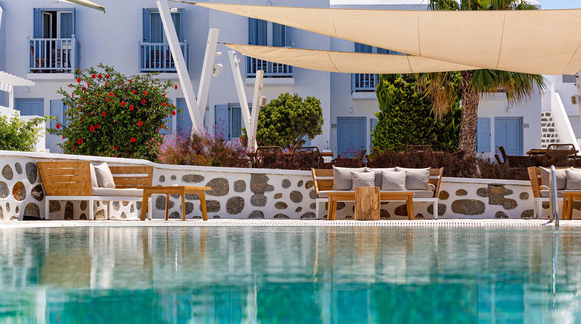 The pool of the Main Section with the outdoor sofas and the plants around the restaurant