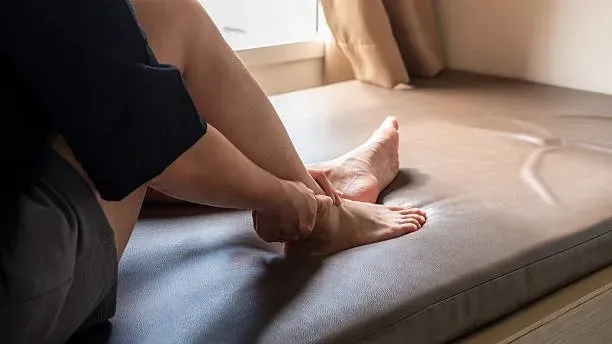 A woman holds her ankle