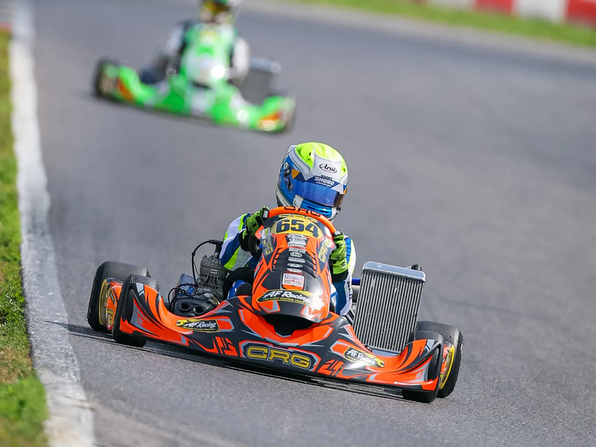 Kart arancione all'inseguimento di un kart verde
