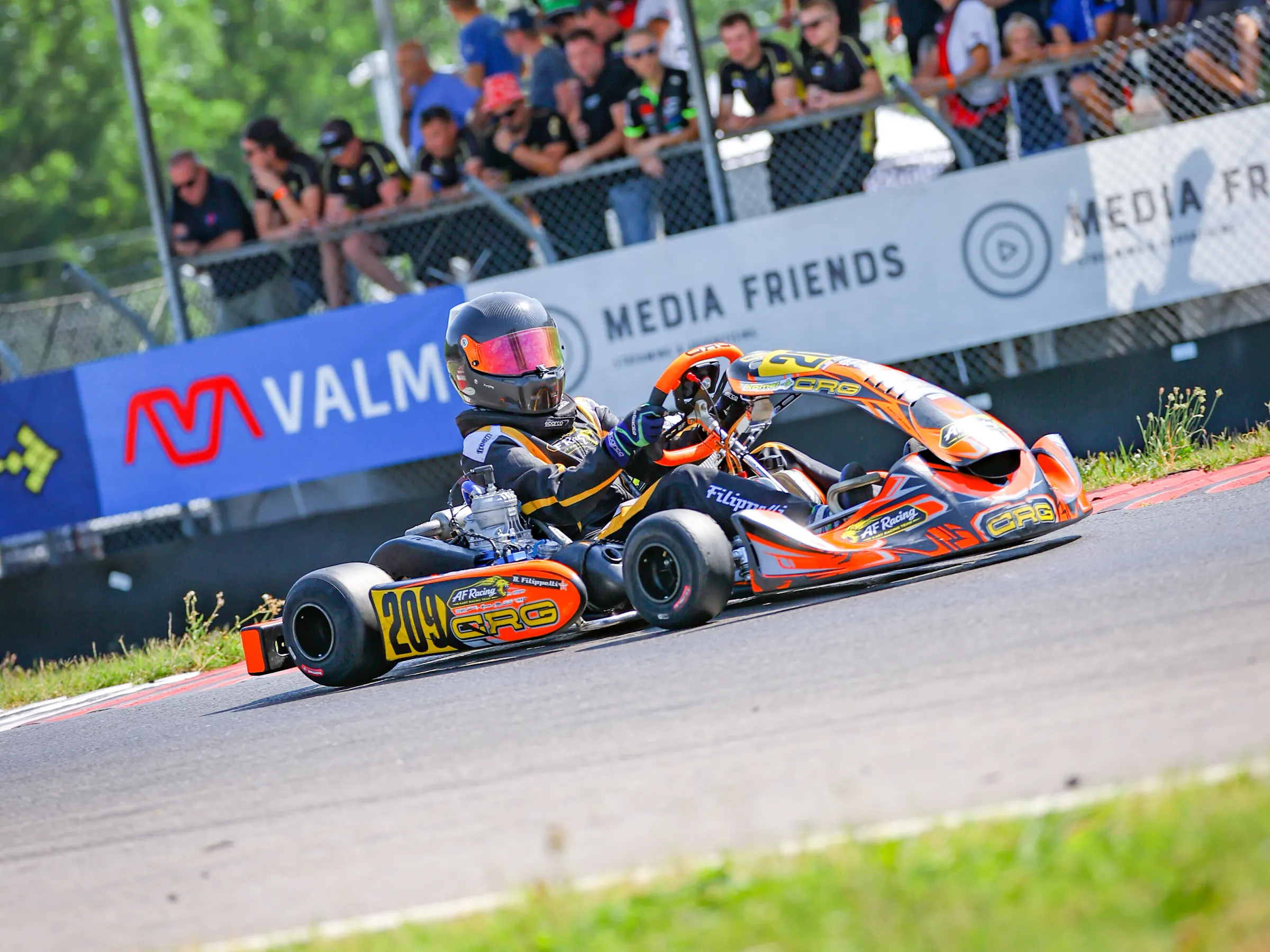 Kart arancione in curva davanti alla tribuna coperta