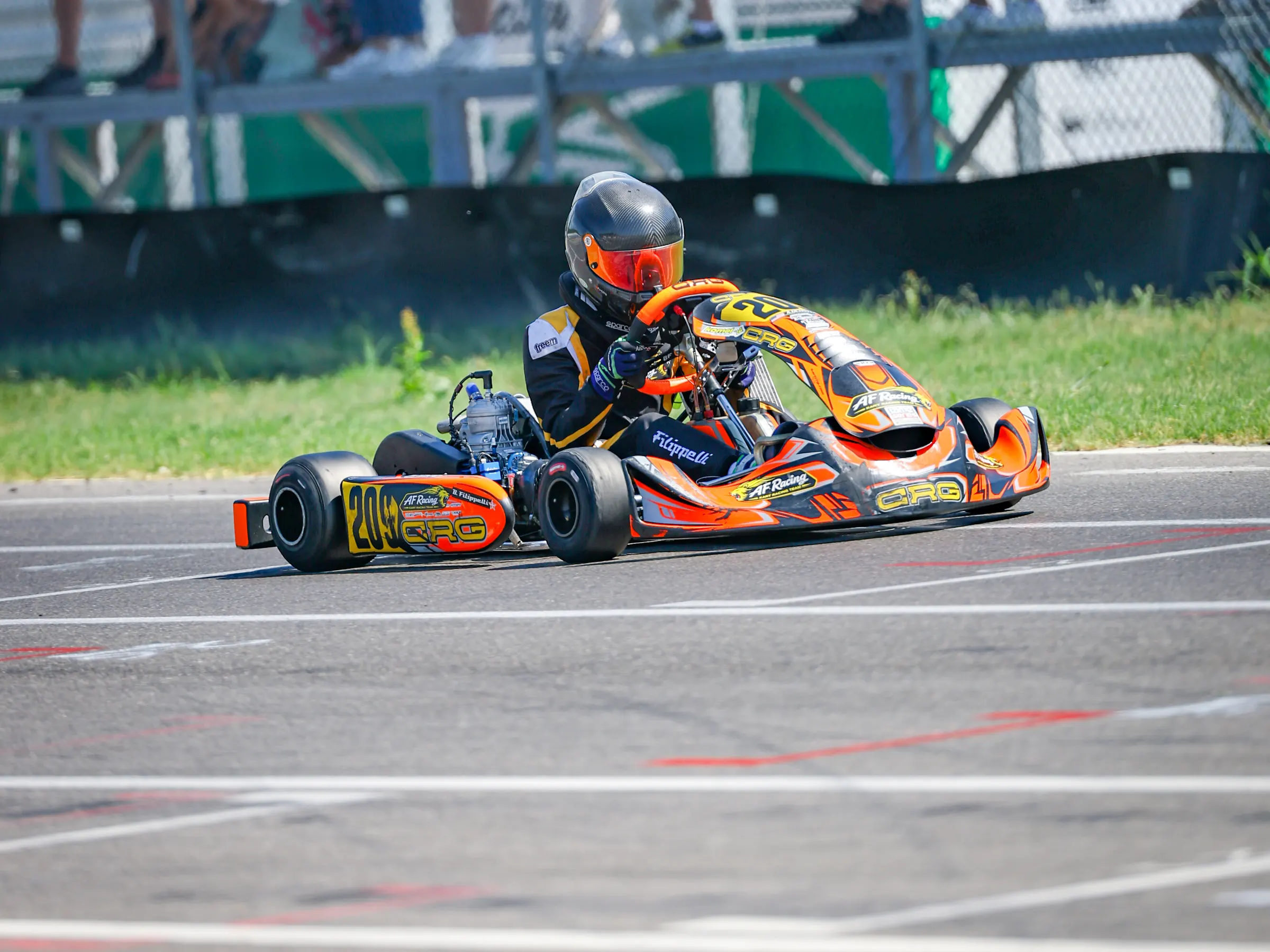 Kart arancione davanti al pubblico in tribuna