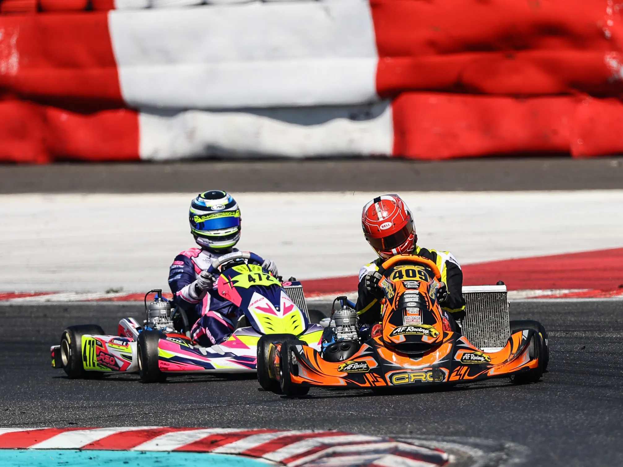 Due kart affiancati davanti alle barriere bianche e rosse