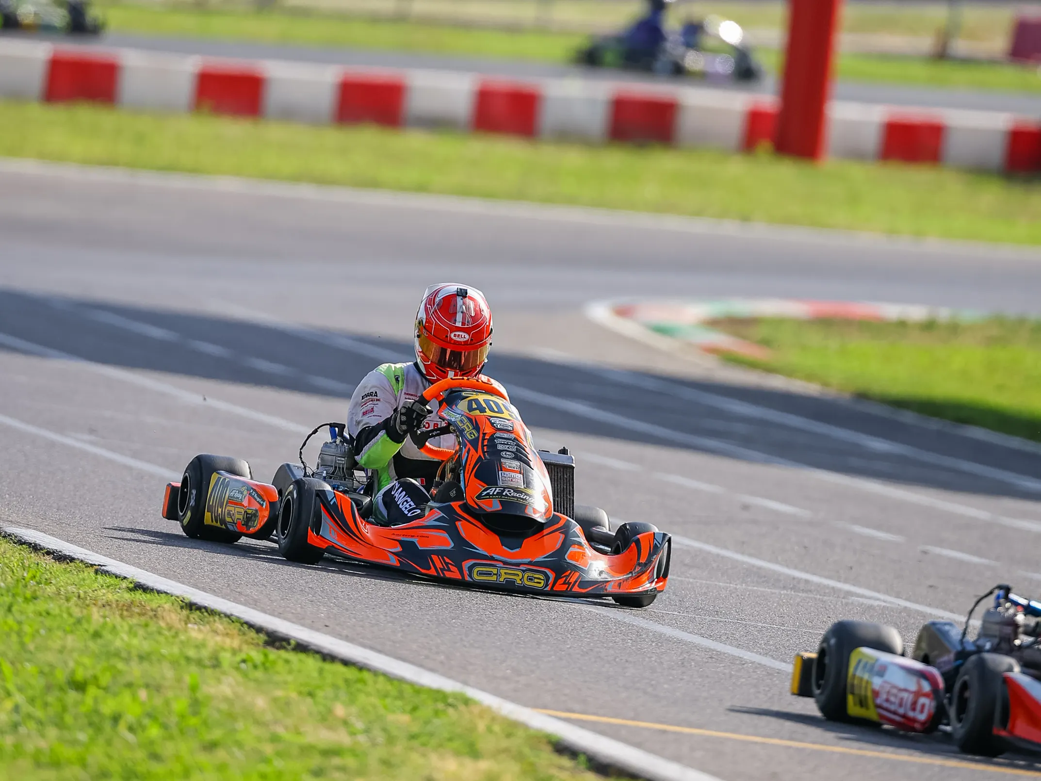 Kart arancione sul rettilineo, con un altro kart sullo sfondo