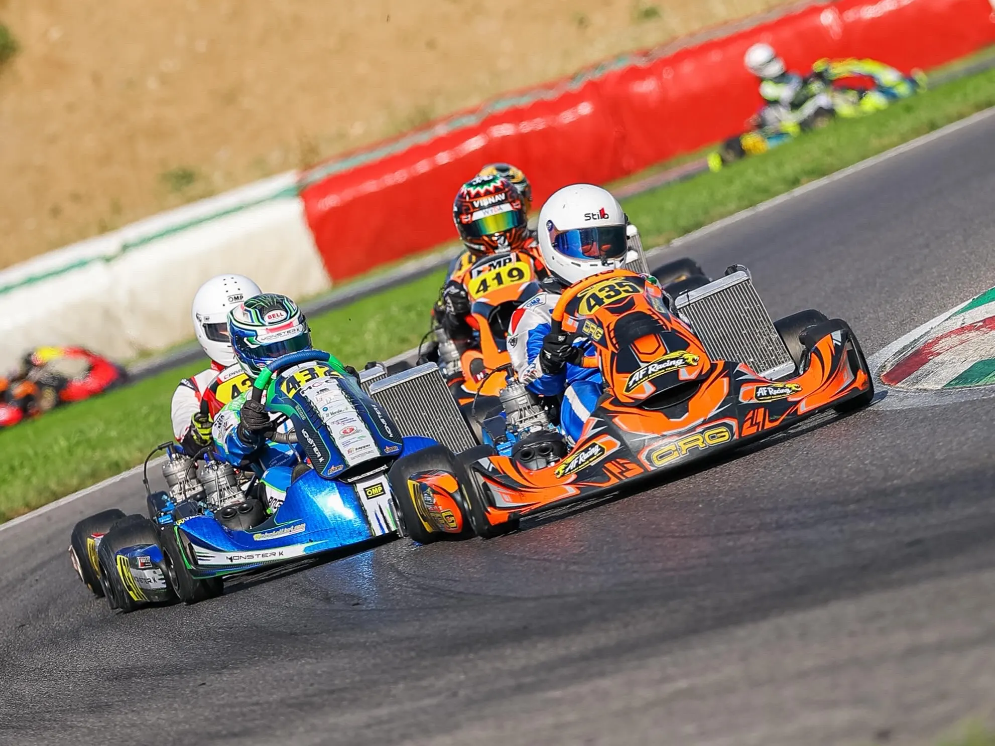 Duello in curva tra un kart arancione e uno blu