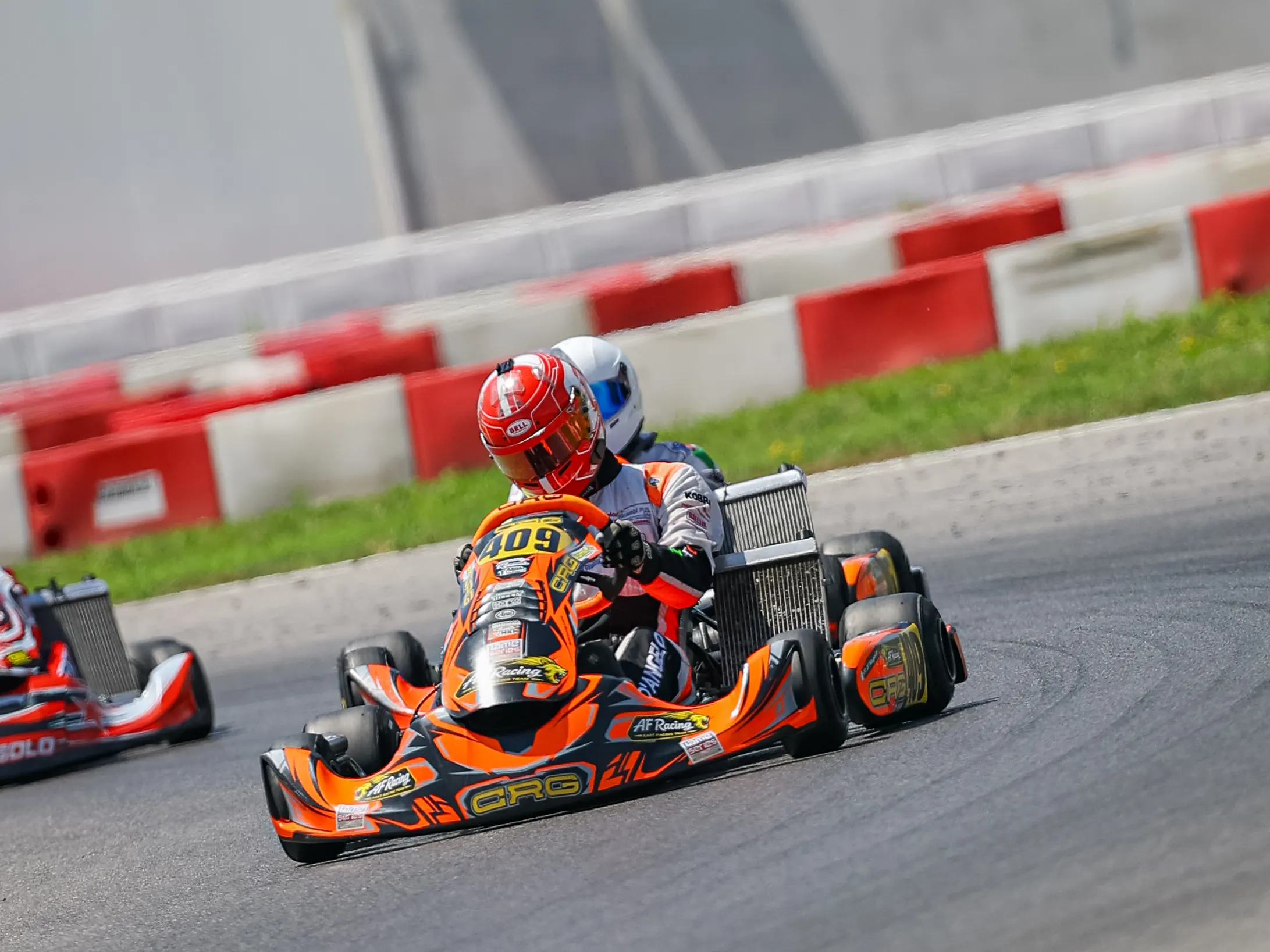 Kart arancione in curva sotto l'insegna del circuito di Franciacorta