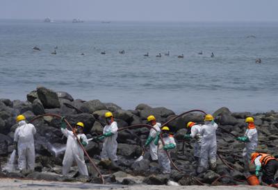 ARCHIVO - Equipos de limpieza trabajan en la playa de Pocitos contaminada por un derrame de petróleo en Ancón, Perú, el 15 de febrero de 2022. Un informe de una comisión de investigación del Congreso publicado el viernes 24 de junio dice que la empresa española Repsol es la principal responsable del derrame. (AP Foto/Martín Mejía, Archivo)