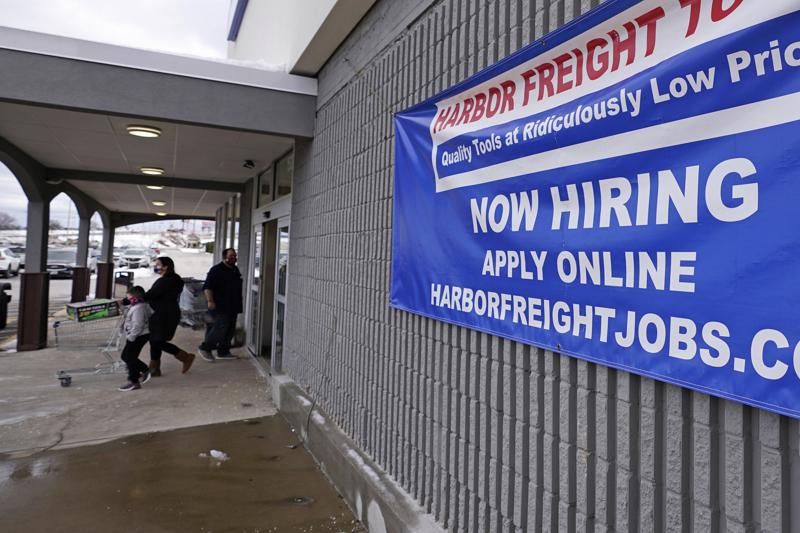 FILE - In this Dec. 10, 2020, file photo, a "Now Hiring" sign hangs on the front wall of a Harbor Freight Tools store in Manchester, N.H. When the U.S. government issues the September jobs report on Friday, Oct. 8, 2021, the spotlight will fall not only on how many people were hired last month. A second question will command attention, too: Are more people finally starting to look for work? (AP Photo/Charles Krupa, File)