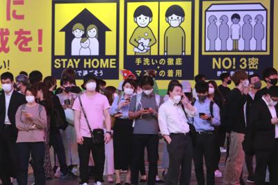 Personas con mascarillas para protegerse de la propagación del coronavirus esperan en un paso peatonal la tarde del lunes 31 de mayo de 2021, en Tokio. La vida nocturna continúa casi como de costumbre debido a que los habitantes de uno de los países con menor índice de vacunación contra COVID en el mundo muestran cada vez una mayor frustración y desafían las medidas de emergencia. (AP Foto/Koji Sasahara)