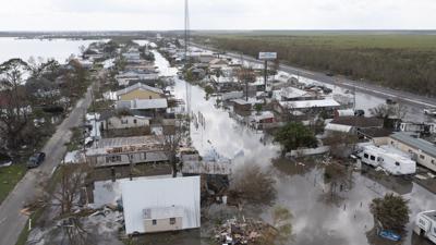 En esta fotografía aérea tomada con un dron, se muestran inundaciones que rodean viviendas dañadas el martes 31 de agosto de 2021, en el condado de Lafourche, Luisiana, luego del paso del huracán Ida. (AP Foto/Steve Helber)