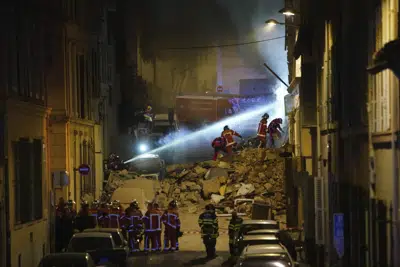 Los bomberos trabajan tras el derrumbe de un edificio el domingo 9 de abril de 2023 en Marsella, en el sur de Francia. Un edificio residencia en la ciudad portuaria francesa de Marsella se derrumbó el domingo de madrugada en una fuerte explosión que se vio seguida por un incendio entre los escombros que complicaba las labores de rescate. (AP Foto)