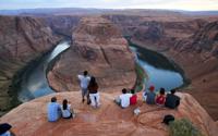 FILE - Visitors view the dramatic bend in the Colorado River at the popular Horseshoe Bend in Glen Canyon National Recreation Area, in Page, Ariz., on Sept. 9, 2011. Some 40 million people in Arizona, California, Colorado, Nevada, New Mexico, Utah and Wyoming draw from the Colorado River and its tributaries. The U.S. Bureau of Reclamation is expected to publish hydrology projections on Tuesday, Aug. 16, 2022, that will trigger agreed-upon cuts to states that rely on the river. (AP Photo/Ross D. Franklin, File)