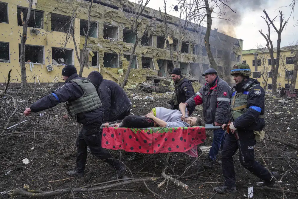 FILE- Iryna Kalinina, 32, an injured pregnant woman, is carried from a maternity hospital that was damaged during a Russian airstrike in Mariupol, Ukraine, on 9 March 2022. Associated Press photographer Evgeniy Maloletka won the World Press Photo of the Year award on Thursday, April 20, 2023, for this harrowing image of emergency workers carrying a pregnant woman through the shattered grounds of a maternity hospital in the Ukrainian city of Mariupol in the chaotic aftermath of a Russian attack. (AP Photo/Evgeniy Maloletka, File)