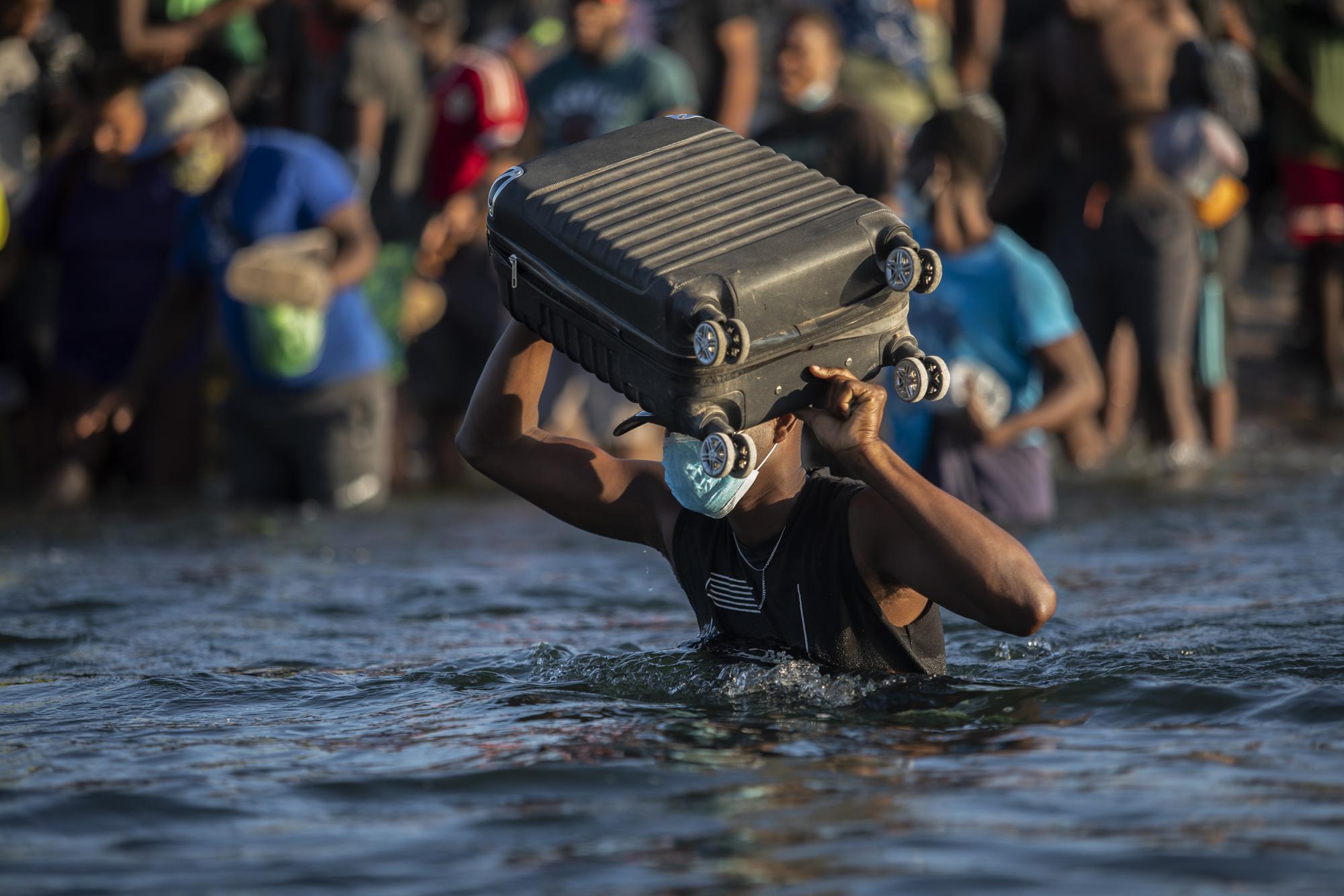 FILE - Migrants, many from Haiti, wade across the Rio Grande river from Del Rio, Texas, to return to Ciudad Acuña, Mexico, Sept. 20, 2021, to avoid deportation from the U.S. The Border Patrol encountered migrants in South Texas more often than ever in June and July, dashing expectations for a common summer slowdown. In September, about 15,000 mostly Haitian refugees were camped under a bridge in the small border town of Del Rio, Texas. (AP Photo/Felix Marquez, File)