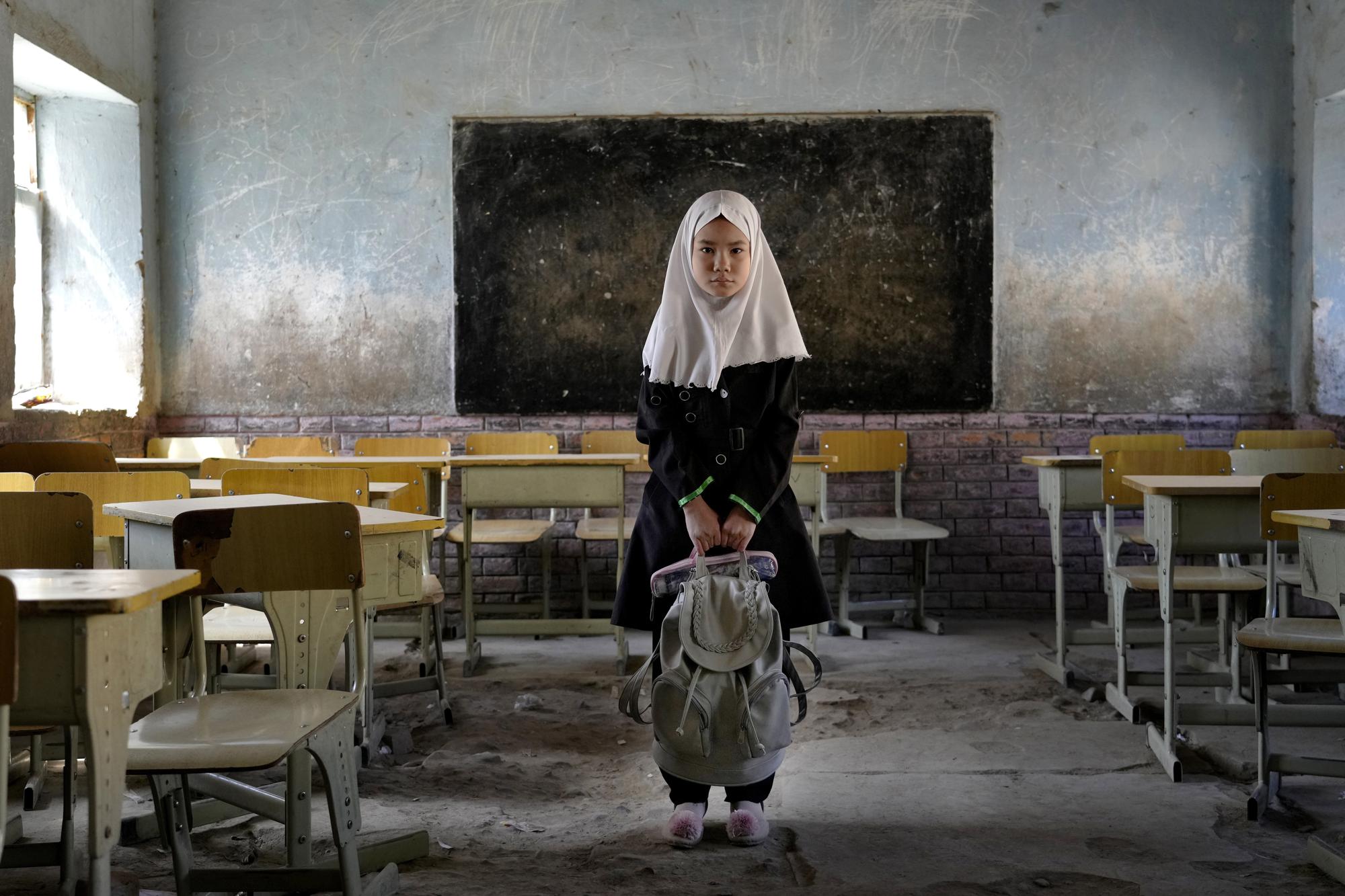 Mahtab, an 8-year-old Hazara Shiite student, poses for a photo in her classroom at the Abdul Rahim Shaheed School in Kabul, Afghanistan, on April 23, 2022, days after a bombing attack at the school. (AP Photo/Ebrahim Noroozi)