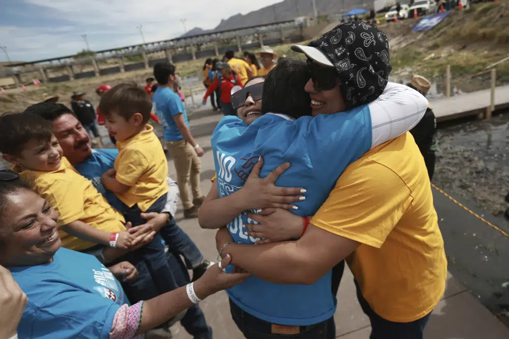 People living in the U.S. embrace with people living in Mexico during the 10th annual "Hugs not Walls" event, on a stretch of the Rio Grande, in Ciudad Juarez, Mexico, Saturday, May 6, 2023. The brief reunions are part of a campaign sponsored by the Border Network for Human Rights, an immigration rights group. (AP Photo/Christian Chavez)