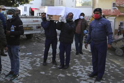 Trabajadores sanitarios trasladan el féretro de una victima de la estampida del templo de Mata Vaishnav Devi, en un hospital en Katra, India, el 1 de enero de 2022. (AP Foto/Channi Anand)