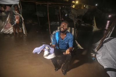 Afectados por el potente sismo que remeció Haití durante el fin de semana tratan de resguardarse de los aguaceros de la depresión tropical Grace en un campo de refugiados en Les Cayes, Haití, el 16 de agosto de 2021. (AP Foto/Joseph Odelyn)