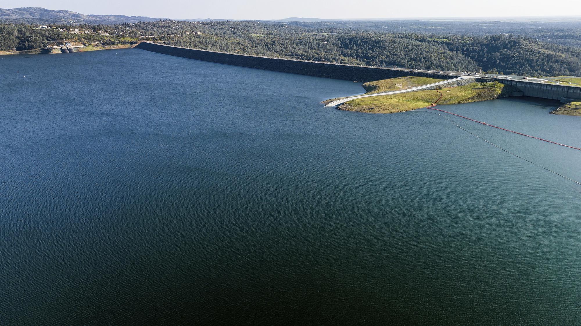 The Oroville Dam, top right, holds back water at Lake Oroville on Saturday, March 25, 2023, in Butte County, Calif. Months of winter storms have replenished California's key reservoirs after three years of punishing drought. (AP Photo/Noah Berger)