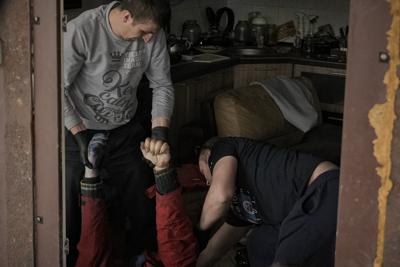 Trabajadores municipales retiran el cadáver de un hombre de una vivienda en Bucha, Ucrania, el jueves 7 de abril de 2022. (AP Foto/Vadim Ghirda)
