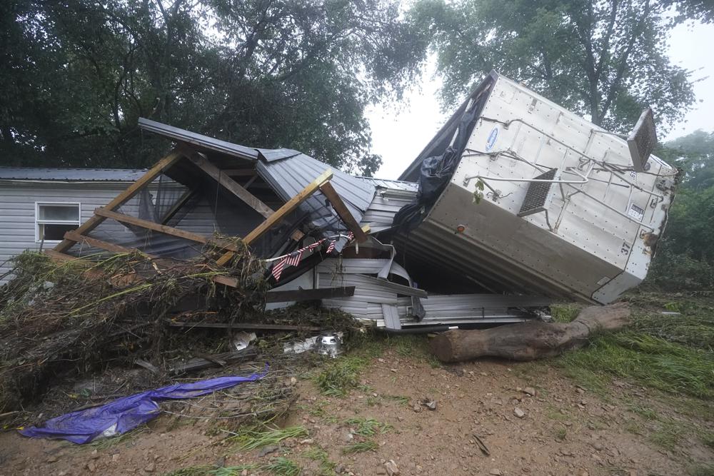 A mobile home and a truck trailer sit near a creek Sunday, Aug. 22, 2021, after they were washed away by flood waters the day before in McEwen, Tenn. Heavy rains caused flooding in Middle Tennessee and have resulted in multiple deaths as homes and rural roads were washed away. (AP Photo/Mark Humphrey)