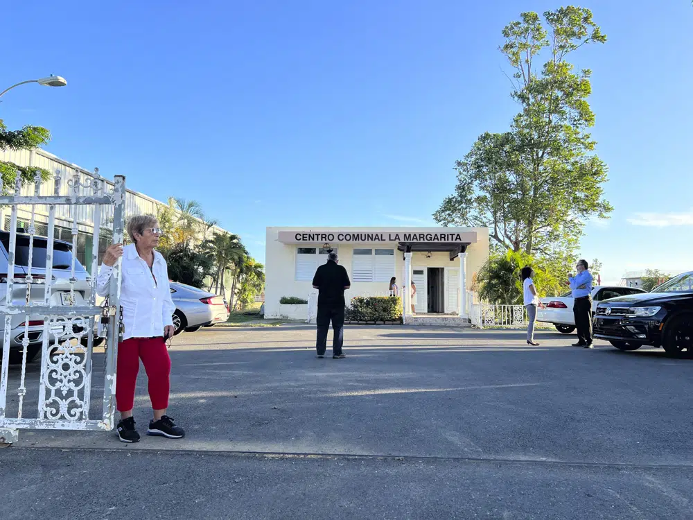 A resident of Salinas, considered one of the most contaminated towns in Puerto Rico, waits for a meeting with U.S. Environmental Protection Agency officials to start, Wednesday, Jan. 25, 2023 in Salinas, Puerto Rico. Emboldened by the attention that the federal government has now placed in Salinas, communities are demanding a massive clean-up and penalties for those contaminating a region where residents have long complained about health conditions. (AP Photo/Danica Coto).