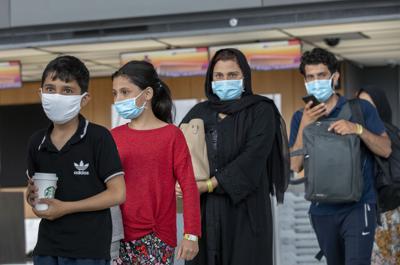 Familias evacuadas de Kabul, Afganistán, caminan por una terminal para abordar un autobús después de llegar al Aeropuerto Internacional Washington Dulles, en Chantilly, Virginia, el martes 31 de agosto de 2021 (AP Foto/Gemunu Amarasinghe)