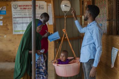 FILE - A child is weighed at a camp for displaced people on the outskirts of Dollow, Somalia, on Sept. 19, 2022. In many Middle Eastern and African nations, climatic shocks killed hundreds and displaced thousands every year, causing worsening food shortages. With limited resources, they also are among the world’s poorest and most vulnerable to climate change impacts. (AP Photo/Jerome Delay, File)