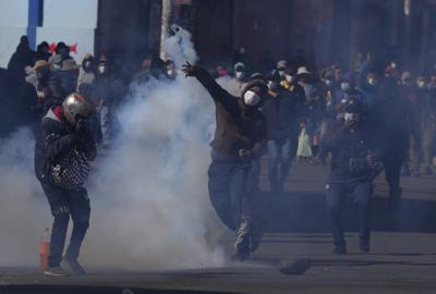 Un cultivador de coca arroja una lata de gas lacrimógeno disparada por la policía antidisturbios durante enfrentamientos cerca del mercado de coca en La Paz, Bolivia, el miércoles 29 de septiembre de 2021. (AP Foto/Juan Karita)