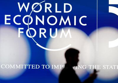 ARCHIVO - La silueta de un hombre frente al logotipo del Foro Económico Mundial de Davos, Suiza, el domingo 19 de enero de 2020. (AP Foto/Markus Schreiber, Archivo)