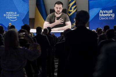 Ukrainian President Volodymyr Zelenskyy addresses by videolink the opening plenary session hosted by Klaus Schwab, Founder and Executive Chairman, World Economic Forum, left, during the 51st annual meeting of the World Economic Forum, WEF, in Davos, Switzerland, on Monday, May 23, 2022. The forum has been postponed due to the Covid-19 outbreak and was rescheduled to early summer. The meeting brings together entrepreneurs, scientists, corporate and political leaders in Davos under the topic "History at a Turning Point: Government Policies and Business Strategies" from 22 - 26 May 2022. (Laurent Gillieron /Keystone via AP)