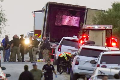 Agentes policiales y personal de emergencias trabajan en el lugar donde docenas de personas fueron encontradas sin vida dentro de un tractocamión y otras más fueron trasladadas a hospitales, el lunes 27 de junio de 2022, en San Antonio, Texas. (AP Foto/Eric Gay)